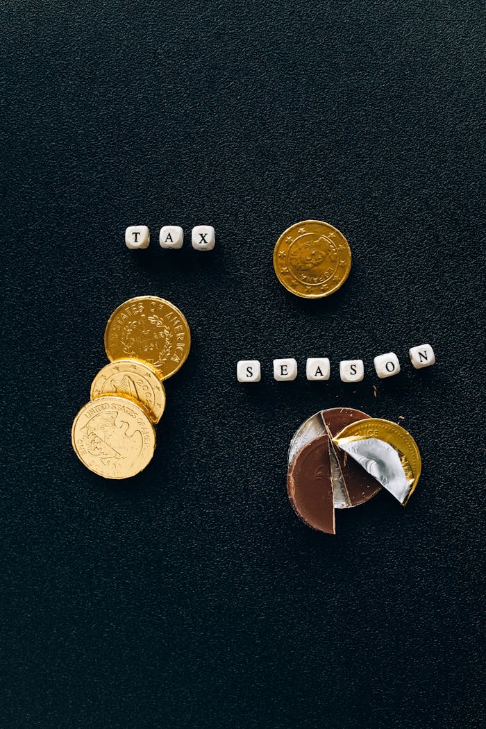 Black background highlighting gold coins and chocolate representing a tax season concept.